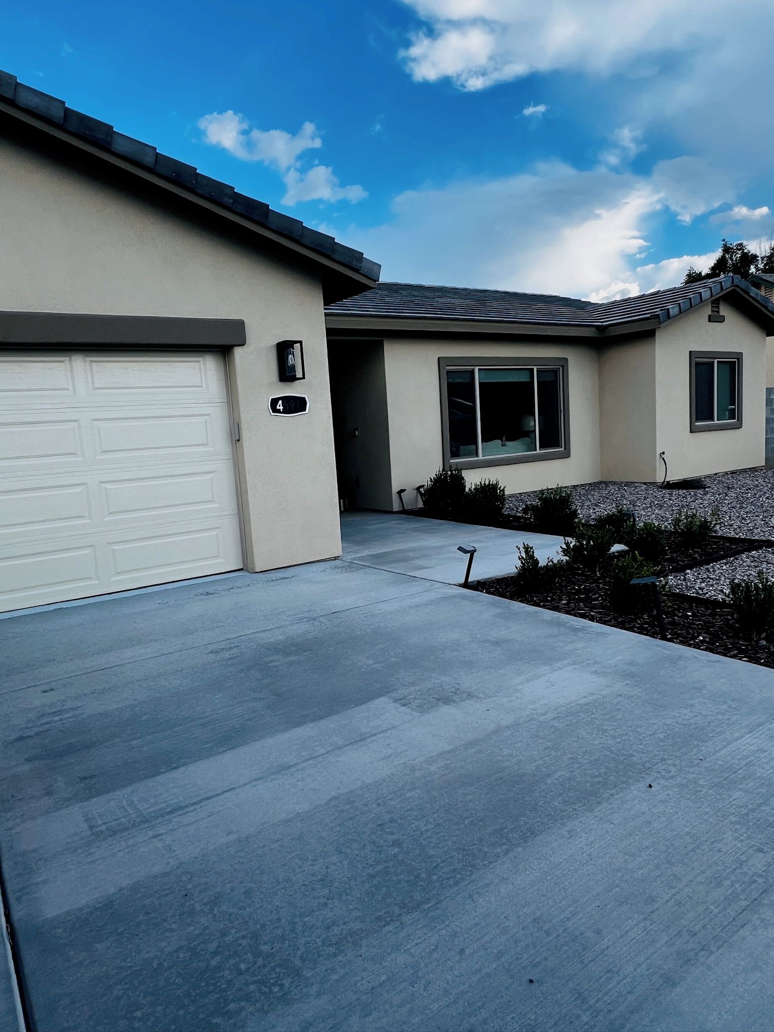 A residential house with a garage, a driveway, and a well-maintained lawn.