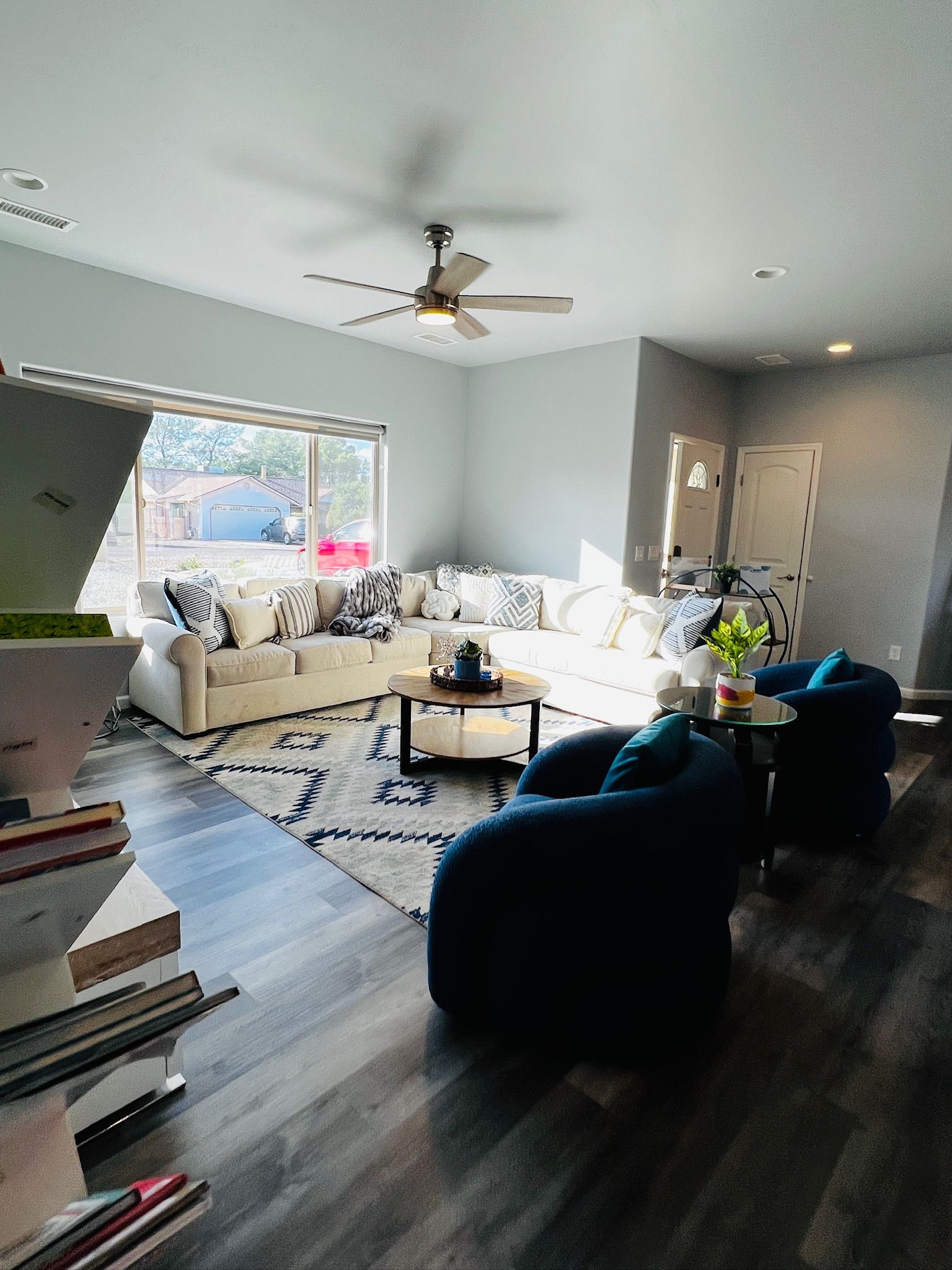 A modern living room with a sectional sofa, a coffee table, and a ceiling fan.