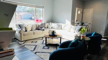 A modern living room with a sectional sofa, a coffee table, and a ceiling fan.