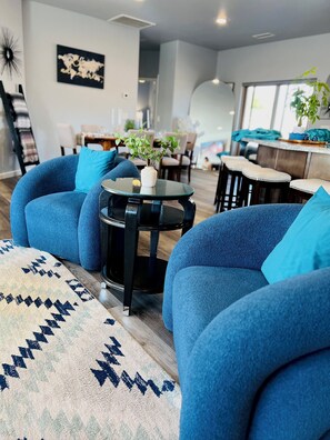 A modern living room with blue sofas, a round coffee table, and a patterned rug. - Bright Star - Hot Tub • Near Sedona & Old Town (Cottonwood)
