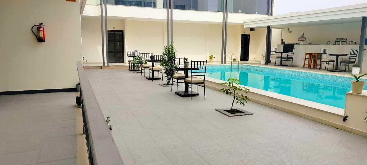 Zona de piscina en la azotea con asientos al aire libre y un extintor.
