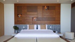 A modern bedroom with a large bed, a tufted headboard, and a wooden accent wall.
