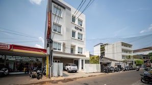 A multi-story building with a 'Cove' sign, a parking area with several motorcycles, and a 'Smart' store on the ground floor. - Cove Senja (Jakarta)