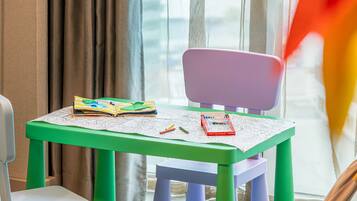 A child's table with a book, crayons, and a toy.