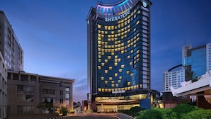 A Sheraton hotel with a modern design, featuring a curved facade and illuminated windows. - Sheraton Kuching Hotel (Kuching)