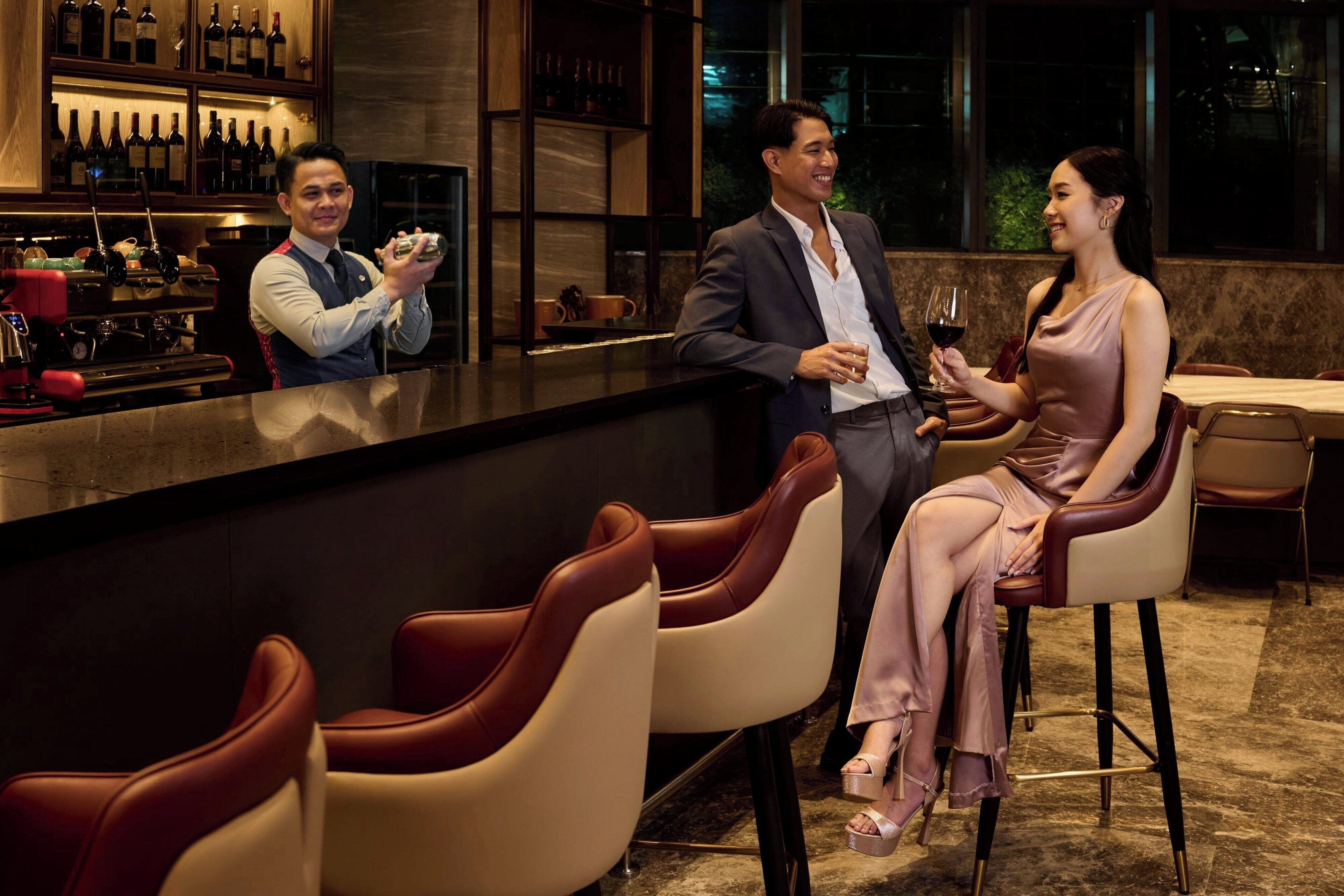 A bar area with seating and a bartender.