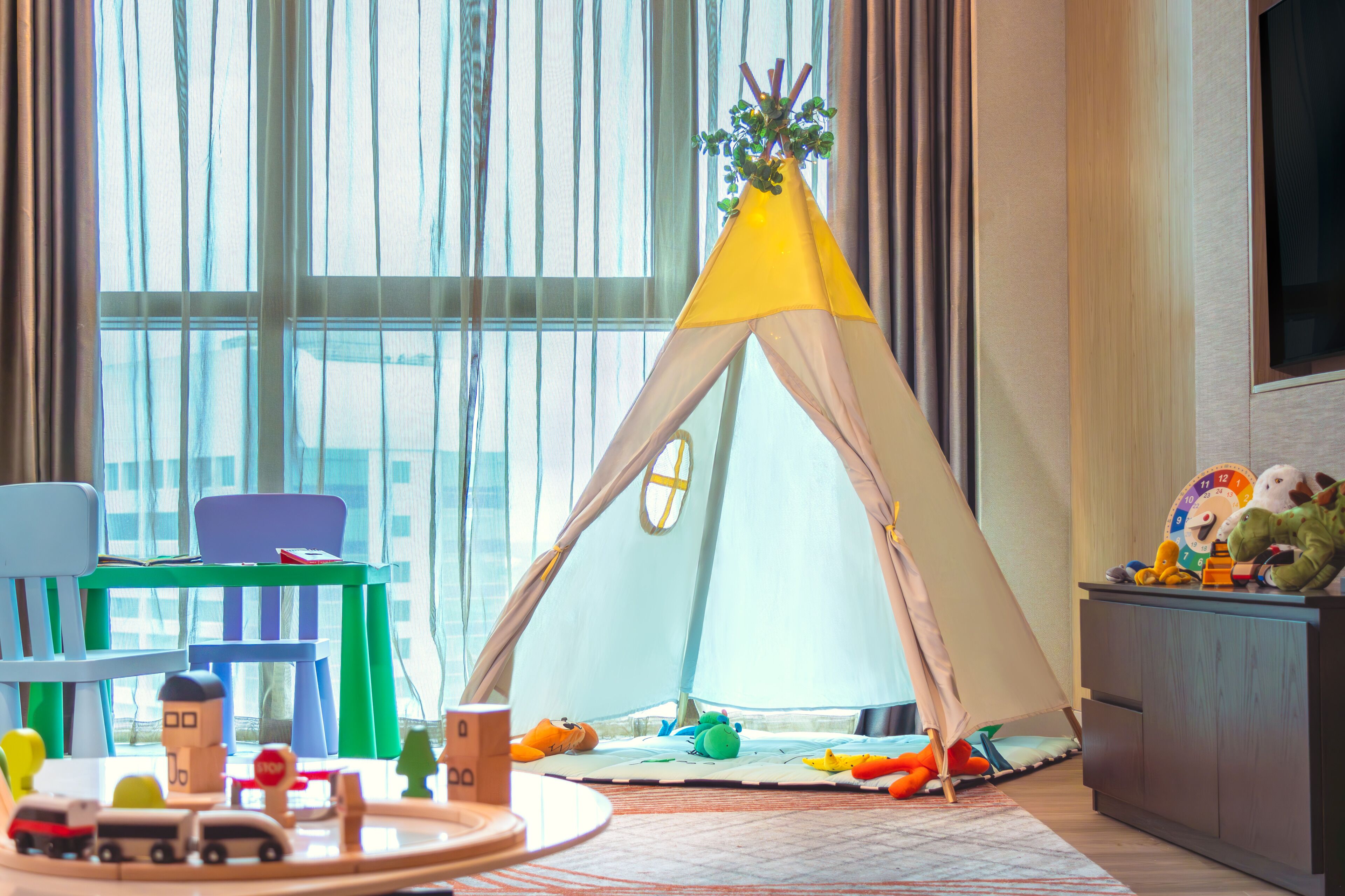 A cozy room with a play tent, toys, and a toy train set.