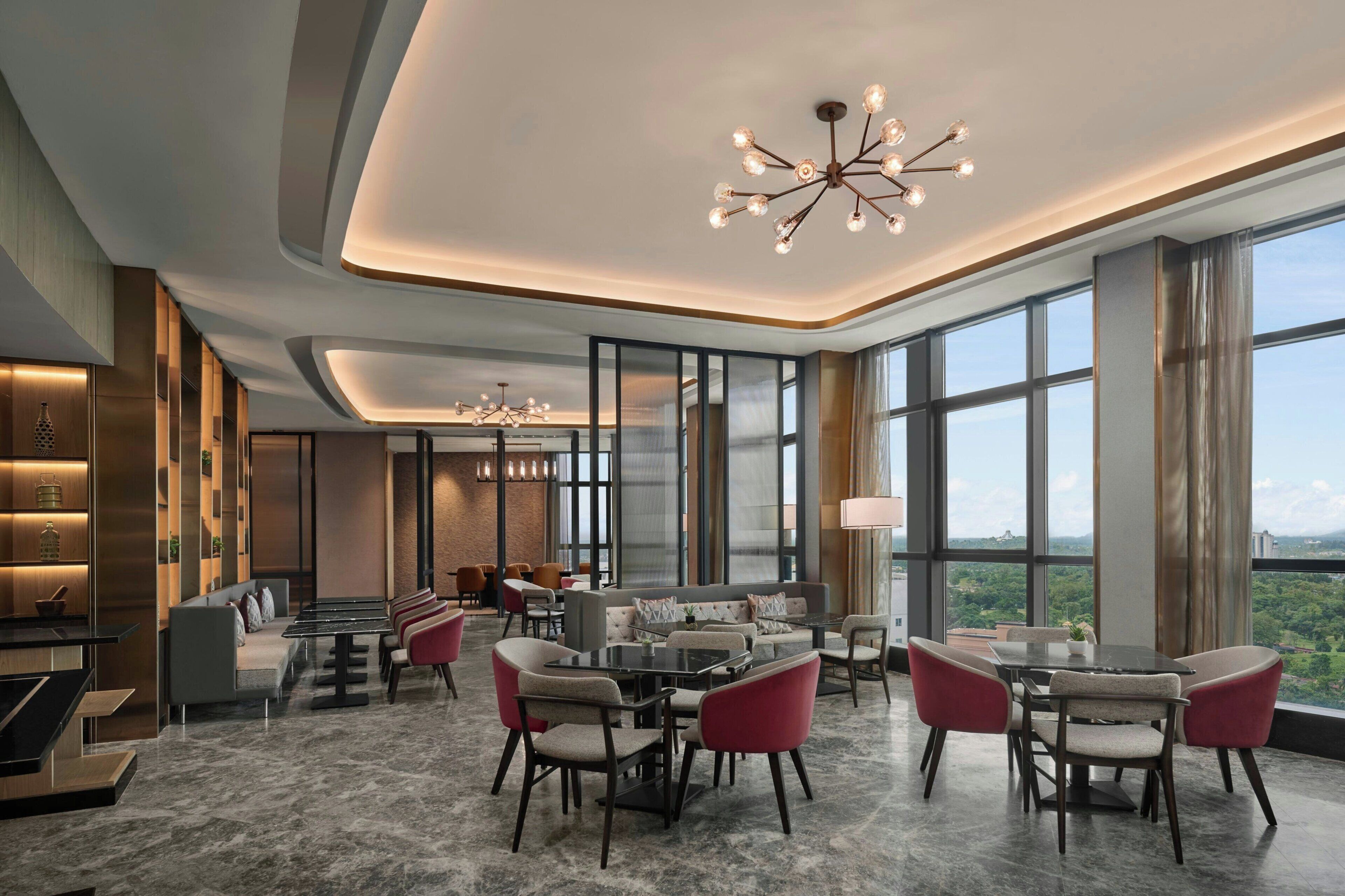 A modern interior with a dining area, seating, and large windows offering a view.