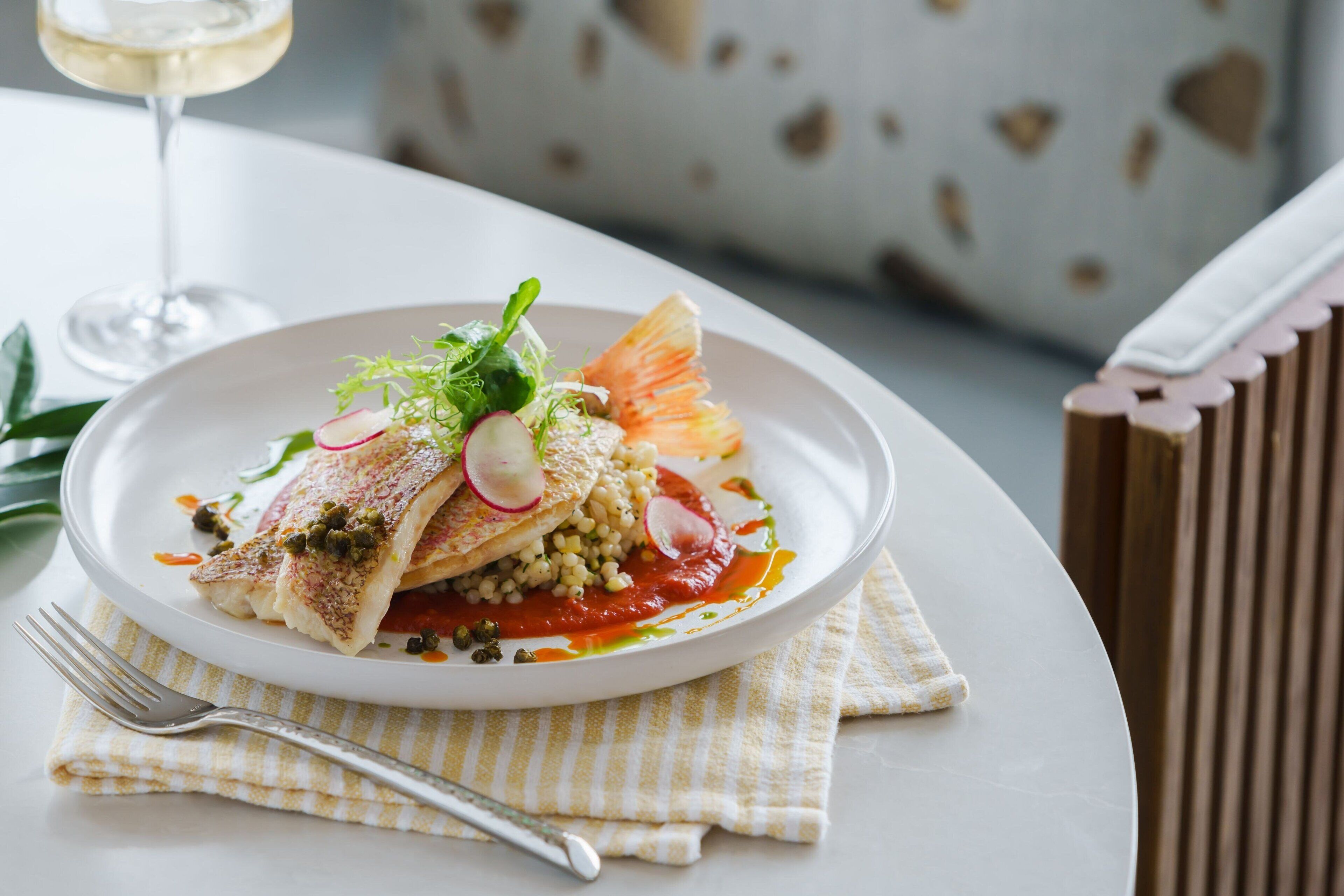 Une assiette de nourriture, avec une fourchette et une serviette, posée sur une table.