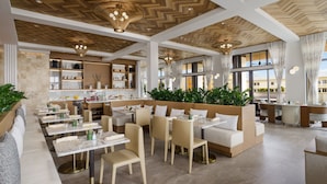 Un restaurant spacieux avec de hauts plafonds, des boiseries et des luminaires modernes.