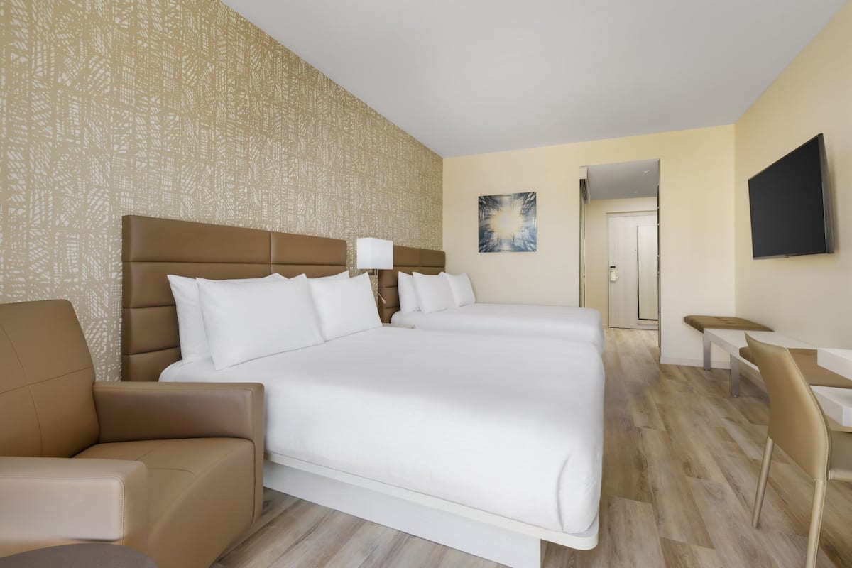 Une chambre d’hôtel avec un grand lit, un bureau et une chaise.