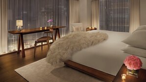 Una habitación de hotel moderna con una cama grande, un escritorio y una silla.