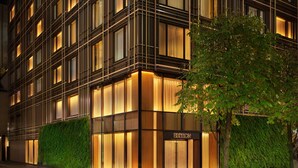 Un edificio moderno con una fachada que presenta una cuadrícula de ventanas y una entrada central identificada con 'EDITION'.