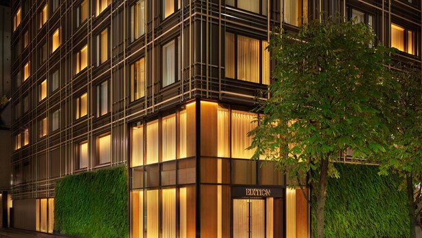 Un edificio moderno con una fachada que presenta una cuadrícula de ventanas y una entrada central identificada con 'EDITION'.