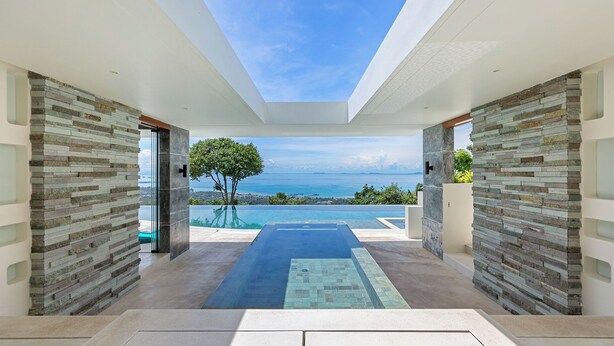 A modern interior with a view of the sea, featuring a glass door, a tree, and a pool. - Villa Spice (Koh Samui)