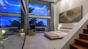 A modern bedroom with a large window, a bed, a desk, and a staircase. - Villa Spice (Koh Samui)