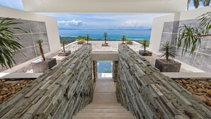 A staircase leading to a pool with a view of the ocean. - Villa Spice (Koh Samui)