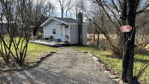 A small house with a porch and a sign reading "The Cottage".