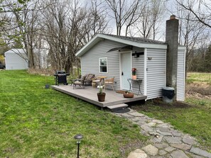 A small house with a porch, outdoor seating, and a barbecue grill. - Country Cottage with beautiful views and easy access to Catskills activities. (Saugerties)