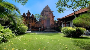 A temple complex with a central entrance, surrounded by lush greenery and a well-maintained lawn. - Jero Delod Guetshouse (Tabanan)