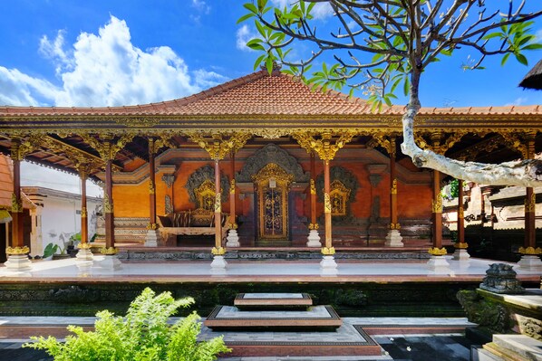 Un templo balinés tradicional con arquitectura ornamentada, un santuario central y un patio circundante.