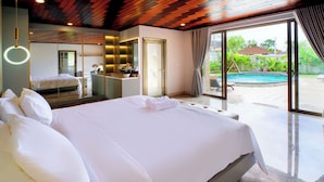 A large bed with white linens in a modern bedroom with a glass door leading to a pool area. - Jero Delod Guetshouse (Tabanan)
