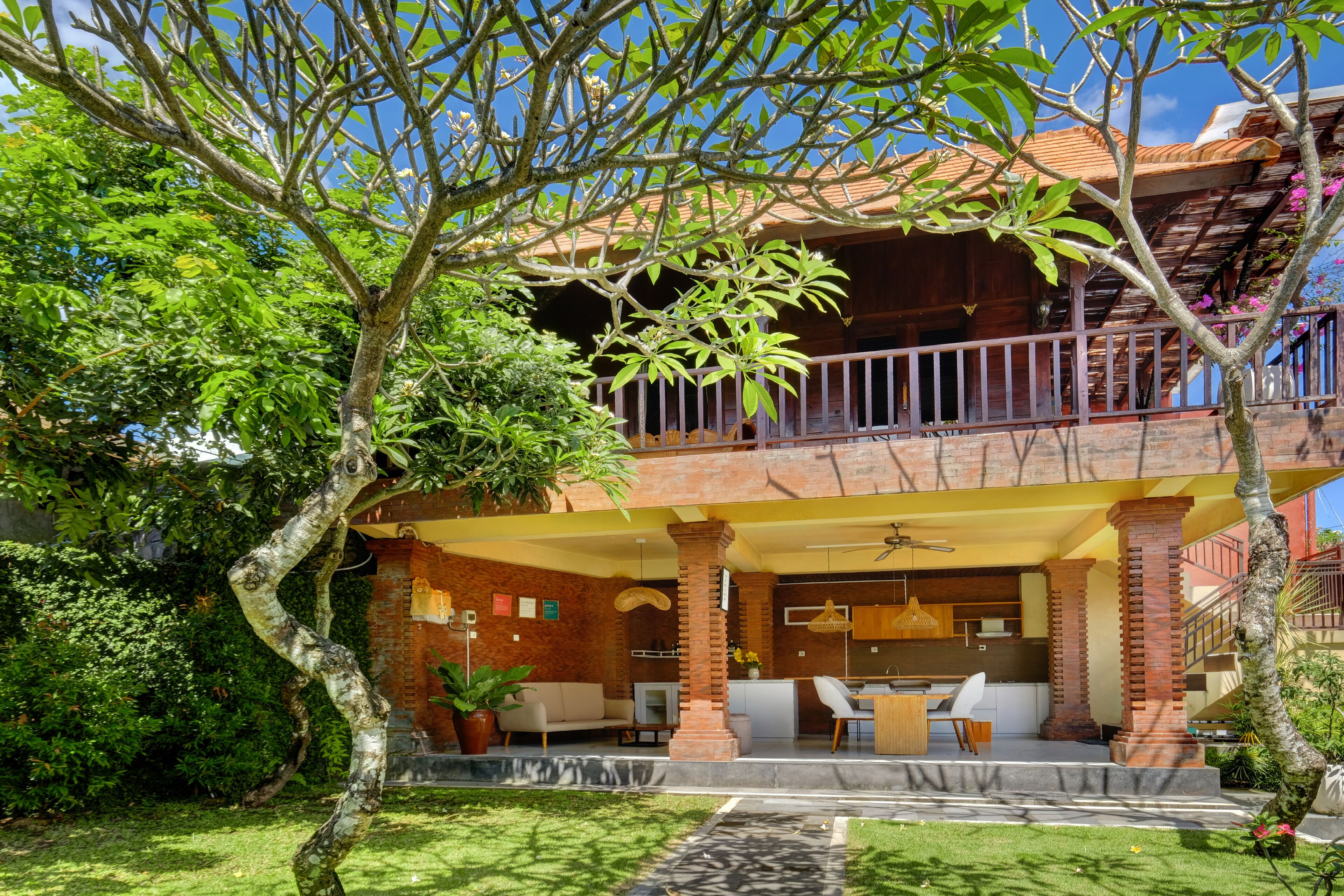 A two-story house with a balcony, a dining area, and a kitchen.