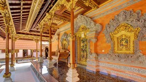 An ornate interior with detailed carvings and golden accents on the ceiling and walls. - Jero Delod Guetshouse (Tabanan)