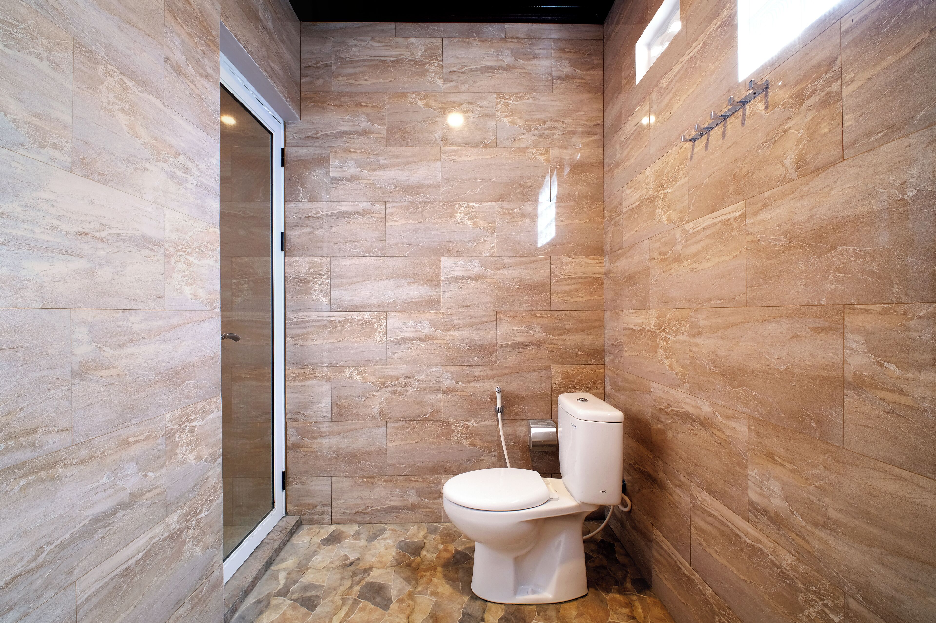 A bathroom with a toilet, shower, and glass door.