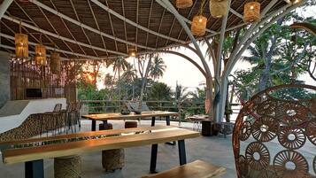 Enjoy meals under a thatched roof, surrounded by lush greenery.