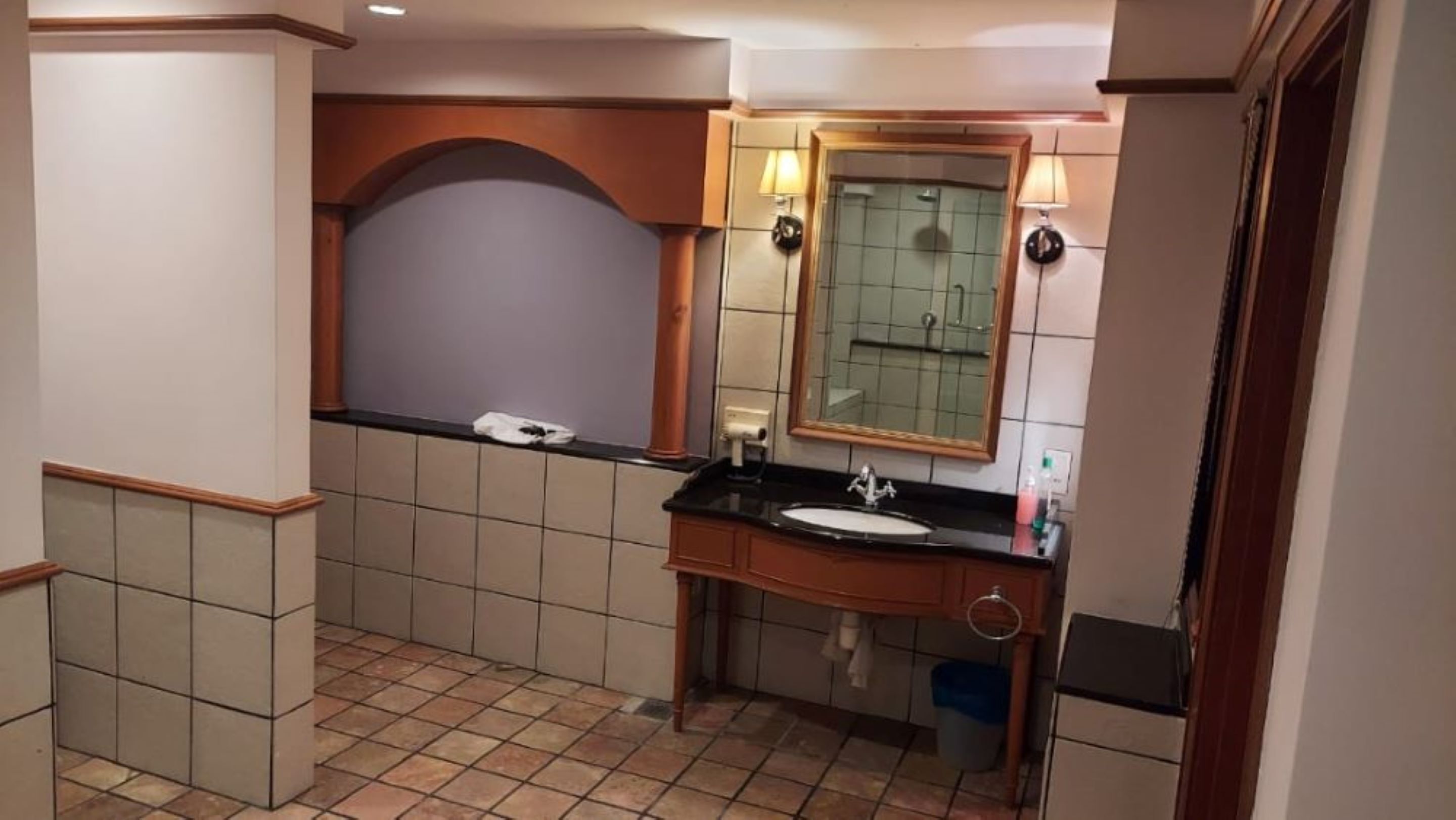 A bathroom with a sink, mirror, and towel rack.