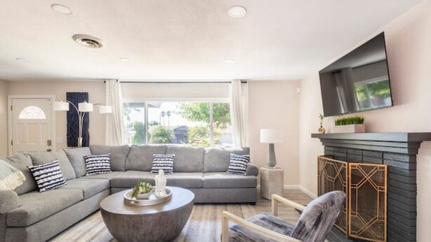 Ein modernes Wohnzimmer mit einem Ecksofa, einem runden Couchtisch und einem Kamin.