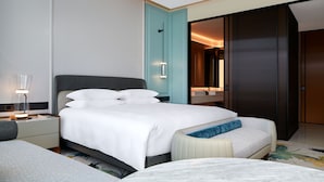A modern hotel room with a large bed, a bedside table with a lamp, a small seating area, and a wardrobe. - Tonino Lamborghini Rosso HangZhou (Suzhou)