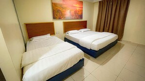 A hotel room with two beds, a painting on the wall, and a curtain on the window. - THE HOTEL (Sandakan)