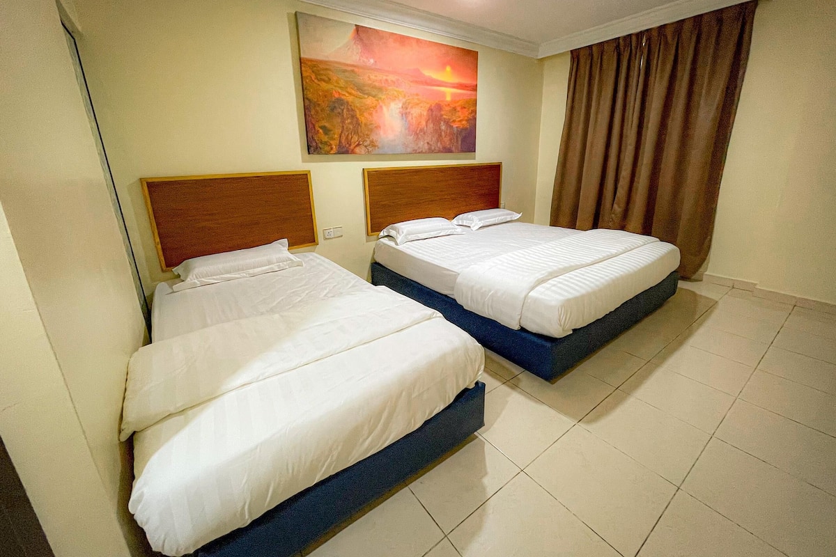 A hotel room with two beds, a painting on the wall, and a curtain on the window.