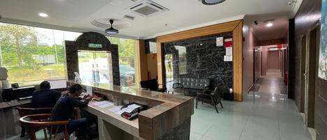 A reception area with a marble counter, seating, and a view of the outside.