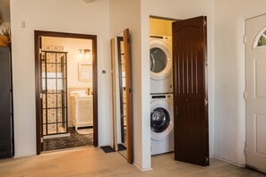 A laundry room with two washing machines and a door leading to a bathroom.