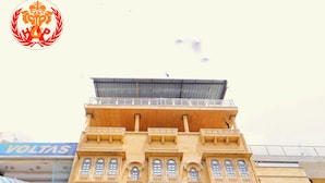 Een meerlaags gebouw met een bord waarop 'Hotel Ajayet Palace' staat.