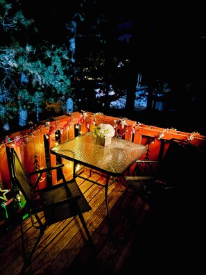 Enjoy dining al fresco in a charming outdoor setting surrounded by a wooden fence and a majestic tree.