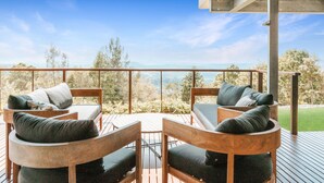 A wooden deck with outdoor seating and a scenic view.