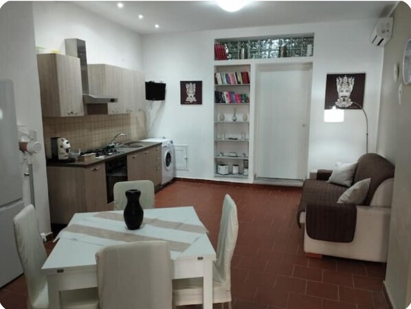 A compact living space with a kitchenette, a dining area, and a seating area.