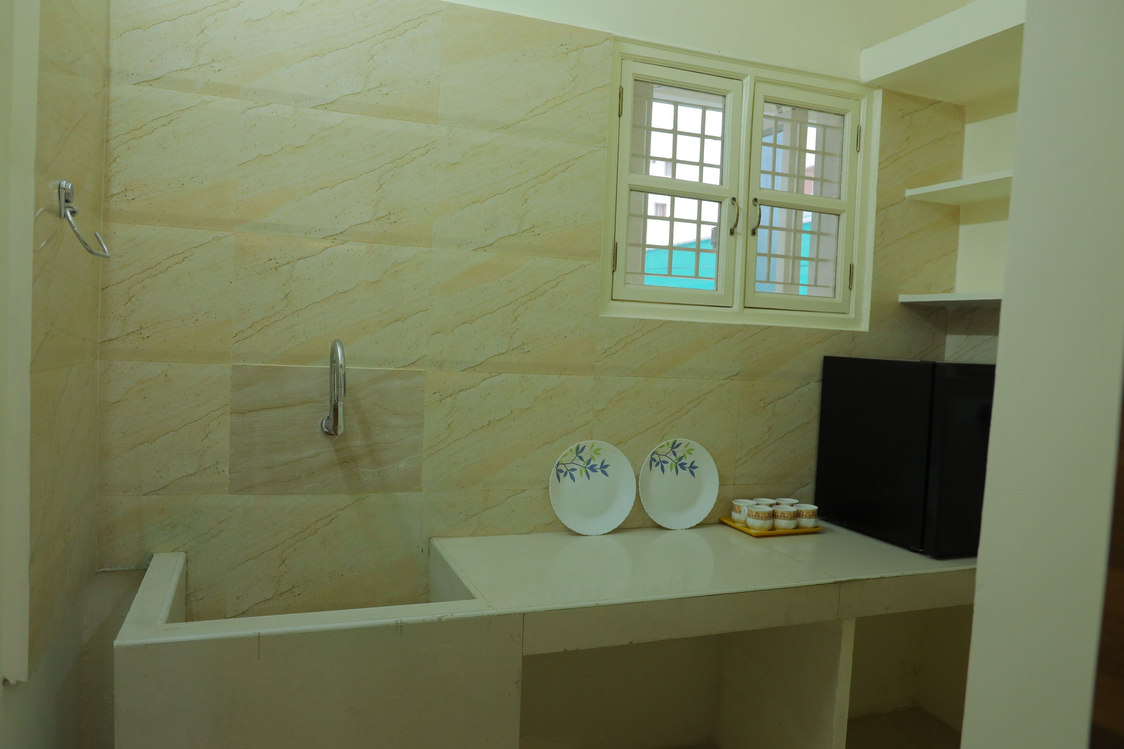 Une salle de bain avec un mur en marbre, une fenêtre, un lavabo et un miroir.