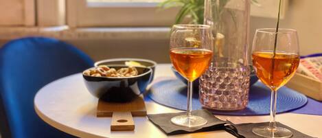 Un tavolo con due bicchieri di liquido ambrato, una ciotola di cereali e un vaso decorativo.