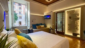 Una habitación de hotel moderna con una cama grande, televisión, balcón y arte decorativo en la pared.