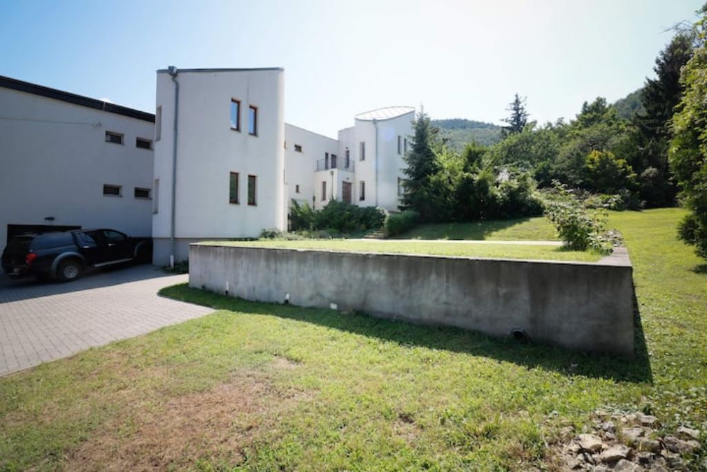 Un edificio moderno con tetto piano e area di parcheggio.