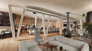 Un intérieur moderne avec un espace bar, des sièges et une grande cheminée.