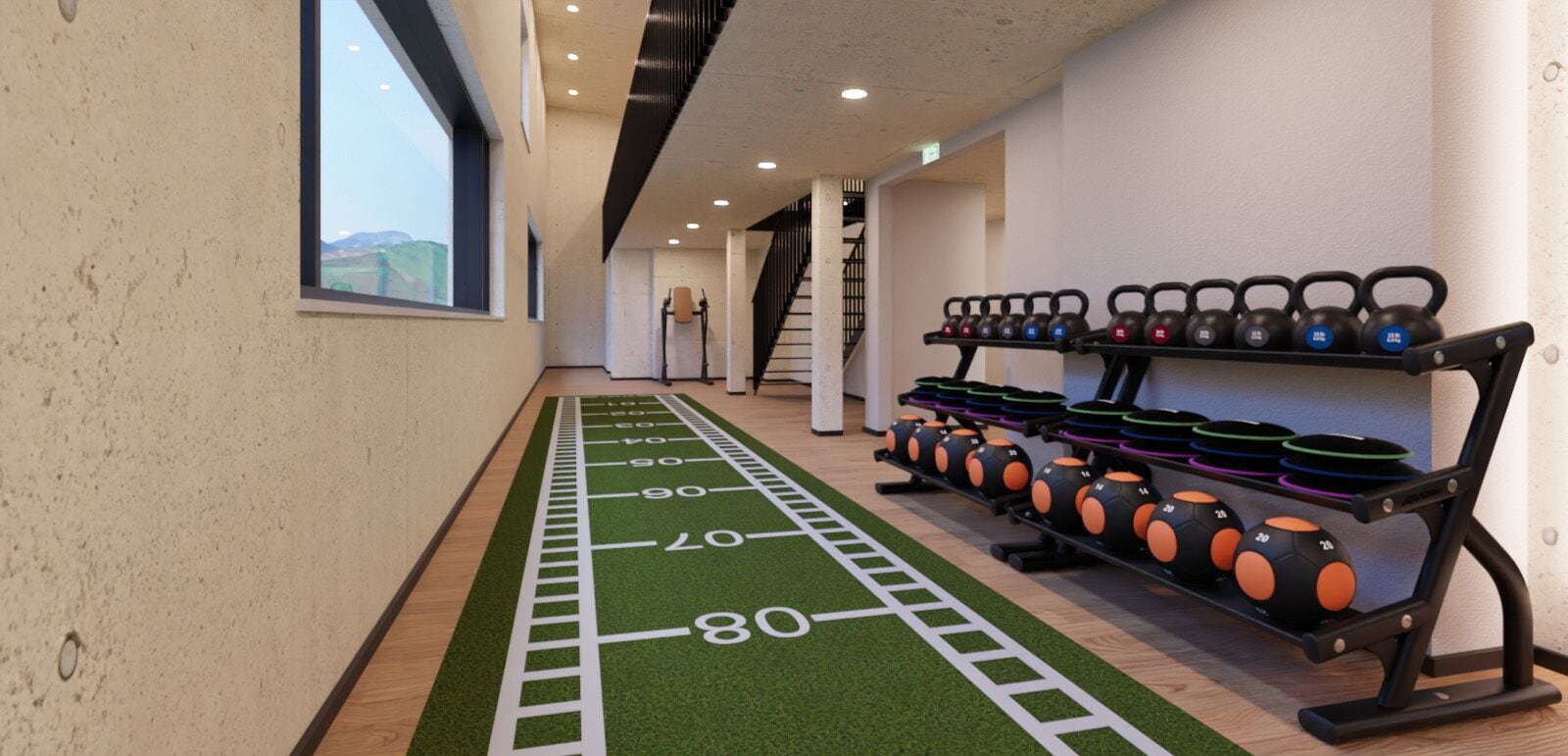 Un gimnasio con pista de correr, mancuernas de kettlebell y una escalera.