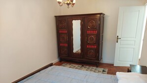 A bedroom with a bed, a wardrobe, and a door.