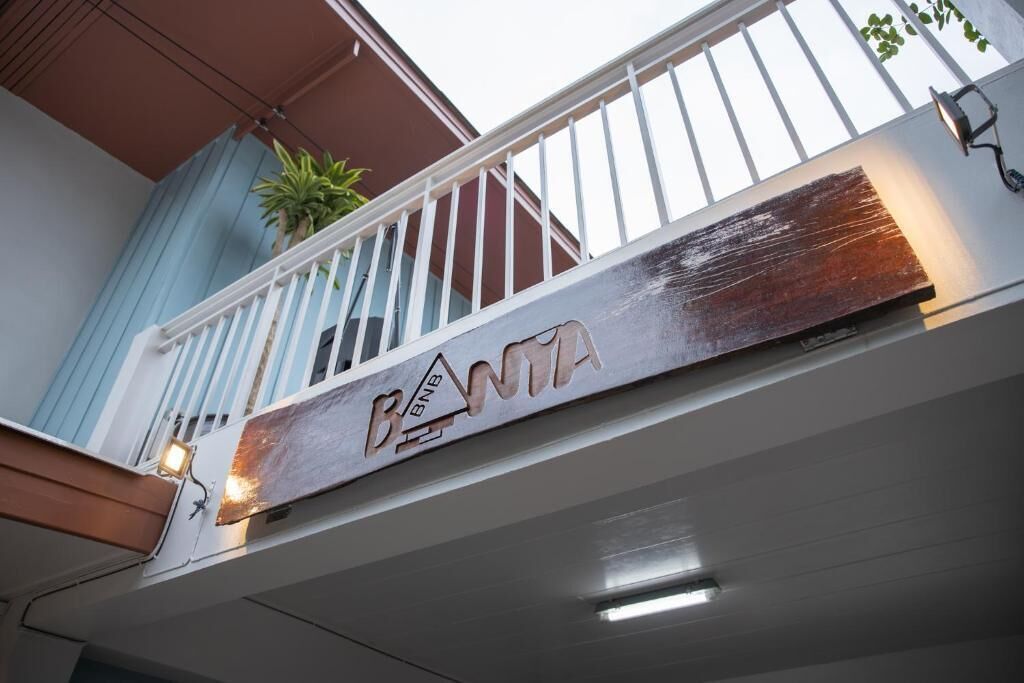 Un balcon avec une pancarte indiquant « BNTIA » et une plante en pot.