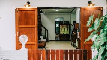 Una puerta de madera que da a una escalera y un cuarto con un armario y objetos decorativos.